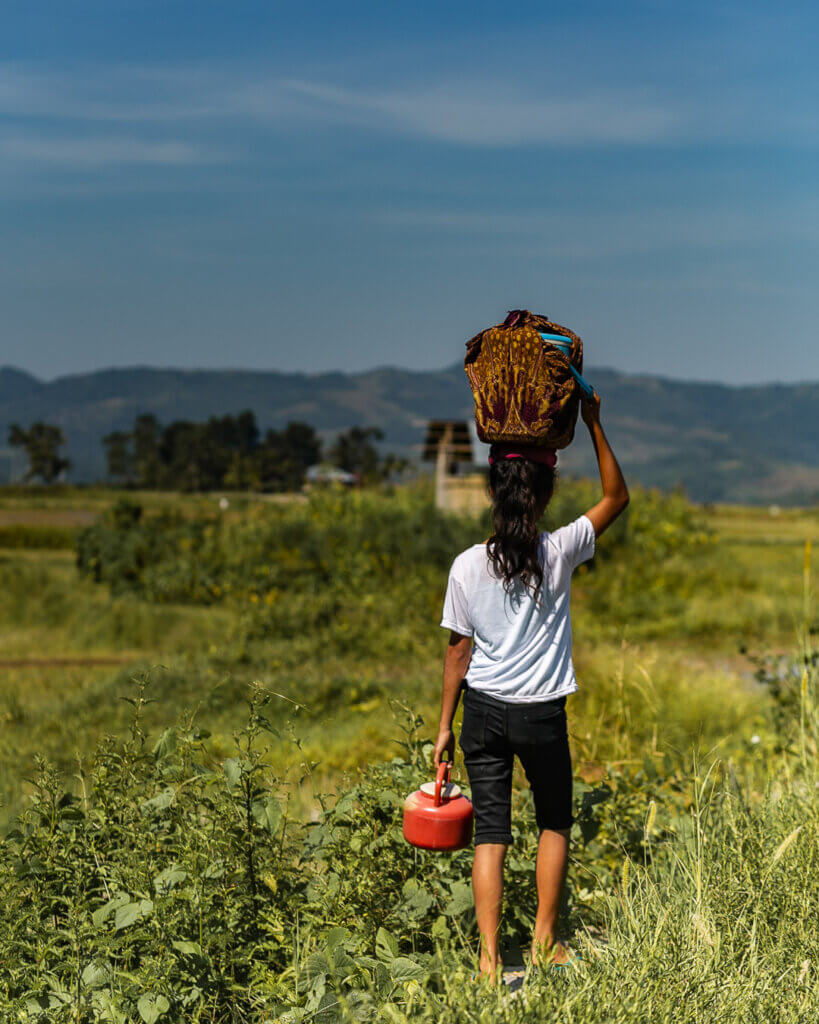 Sumbanese woman carrying goods on her head. 