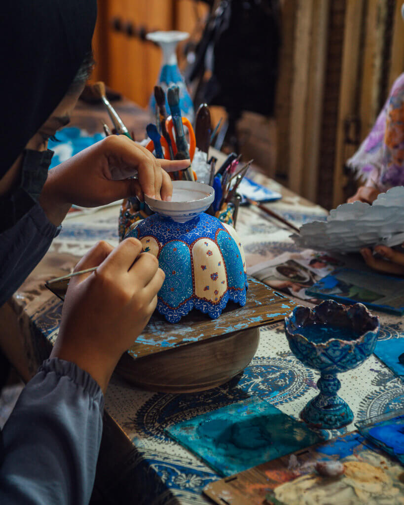 girsl painting a plate in Grand Bazaar in Isfahan Iran