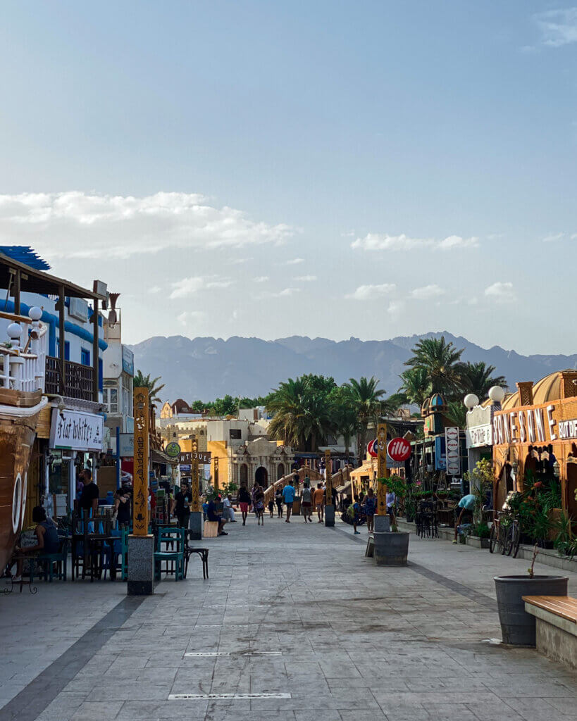 Street view of Dahab city center, showcasing its vibrant shops, cafes, and colorful atmosphere.