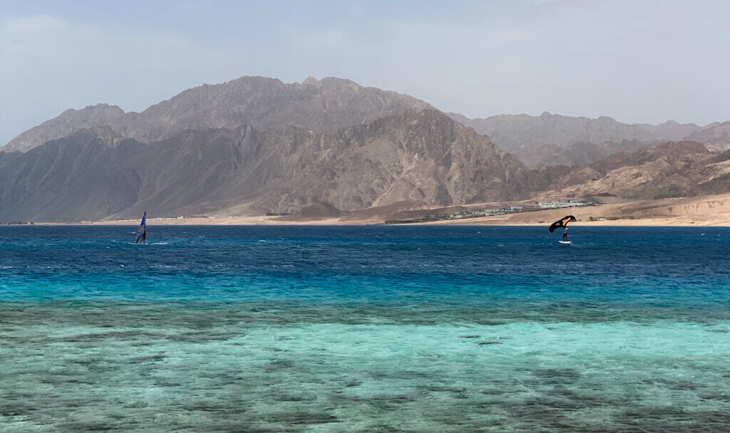 Windsurfers showcasing their skills at Dahab Lagoon, an iconic spot for water sports in Egypt.