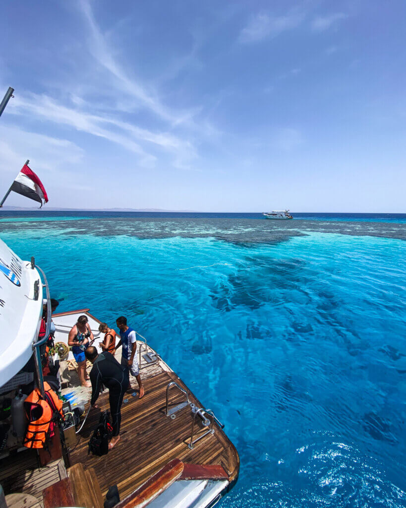 Divers preparing to dive into the turquoise waters from the boat in Dahab, Egypt.