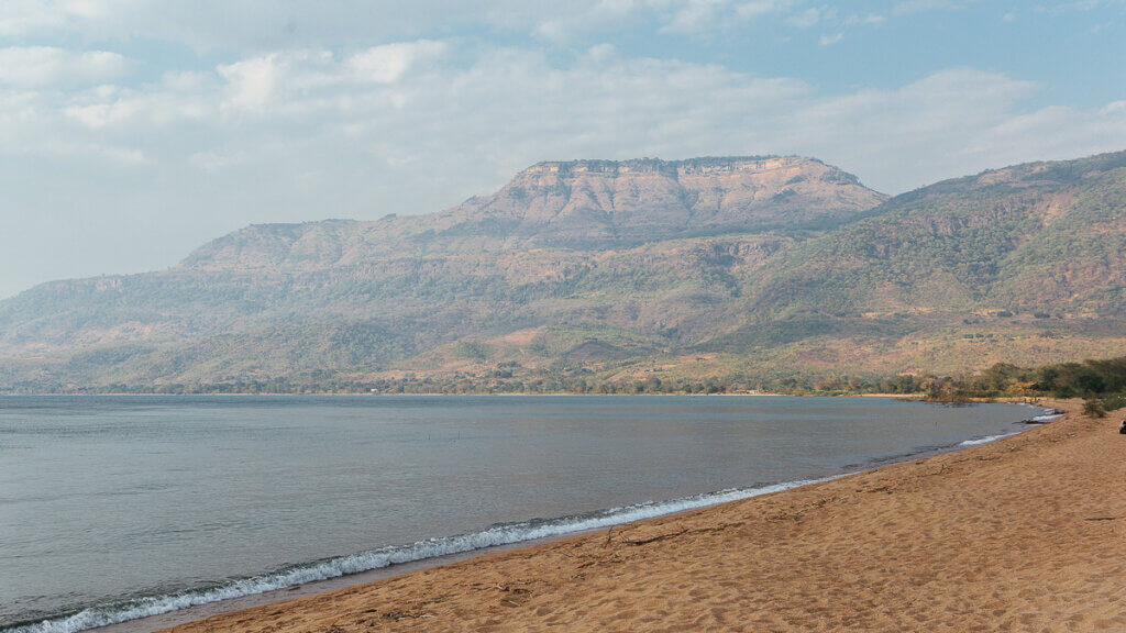 Scenic view of Lake Malawi with clear blue water and a vibrant lakeshore. - Malawi things to see