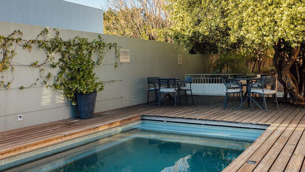 Swimming pool at Windhoek Luxury Suites surrounded by lush greenery