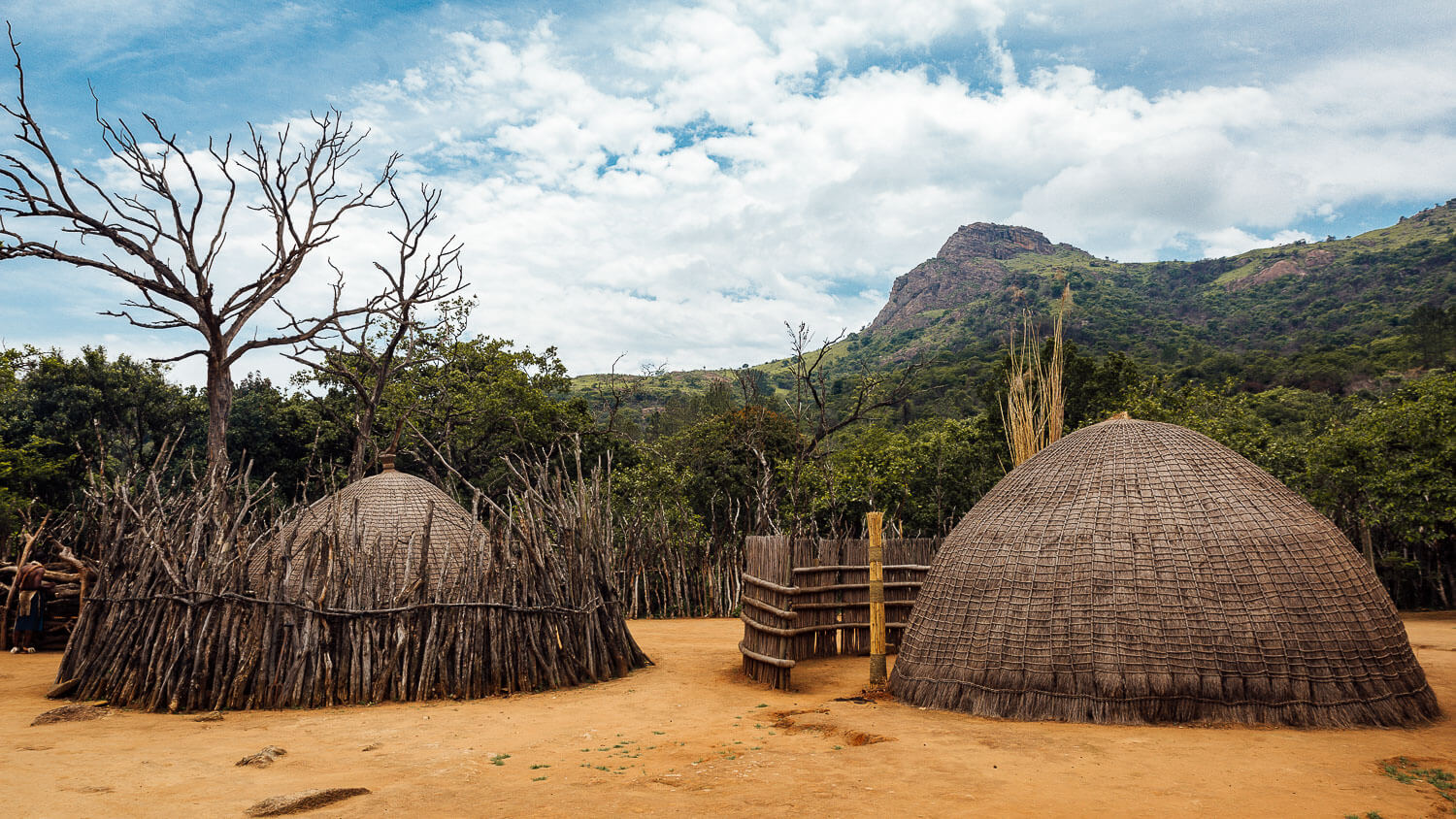 A traditional Swazi hut surrounded by lush greenery in Eswatini.