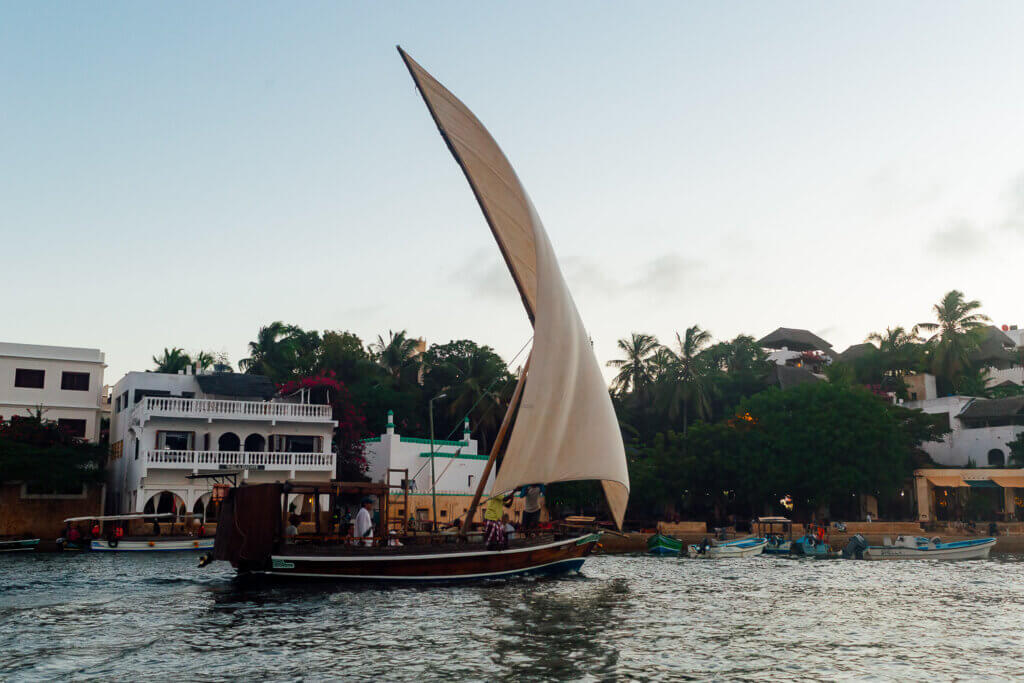 Traditional wooden dhow sailing in the Lamu Archipelago Kenya at sunset