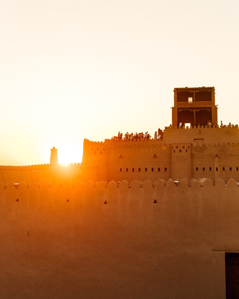 Sunset silhouettes over Khiva minarets from fortress walls